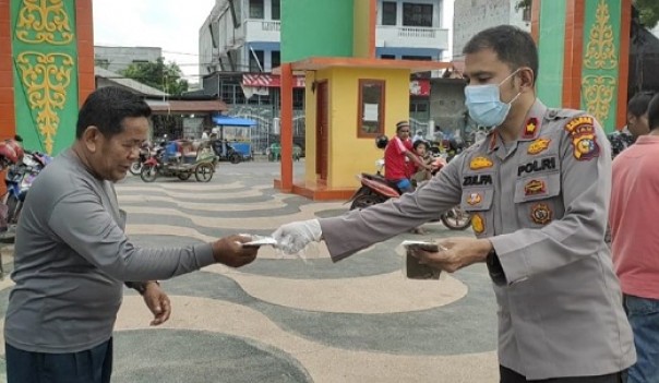 Kapolres Inhu Pimpin Langsung Pembagian Masker dan Nasi Bungkus 