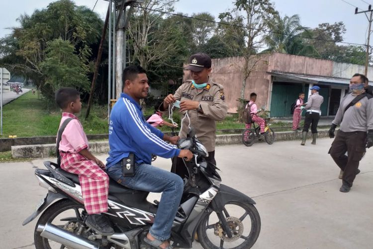 Kapolsek Rupat Bagikan Masker Kepada Pengendara Untuk Antisipasi Dampak Kabut Asap